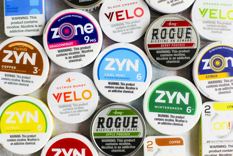 Lata branca aberta de snus (nicotine pouch) sobre fundo verde menta